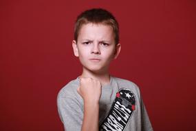 photo of an angry boy on a burgundy background