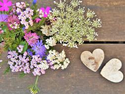 bouquet of wildflowers and wooden hearts on the table