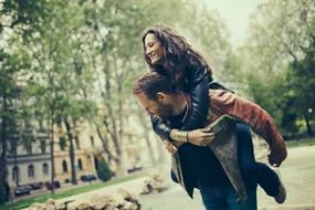 man carrying woman on his back