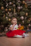 little girl on the background of a Christmas tree