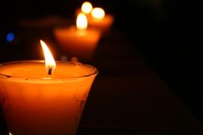 burning candles in glass candlesticks in the dark