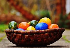 multicolored easter eggs in wicker basket