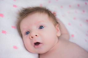 caucasian Baby laying on Blanket looking up