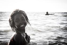 Smiling girl in the water in light