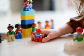 girl is playing with lego dolls