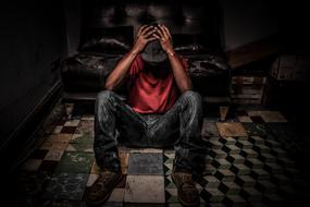 depressed young man sitting on the floor