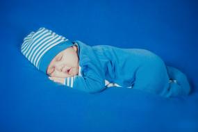 newborn baby sleeps on a blue plaid