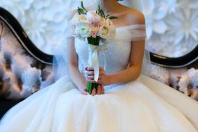 Bride in the beautiful white dress with the colorful flowers