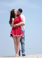 romantic couple in love stands against blue sky background