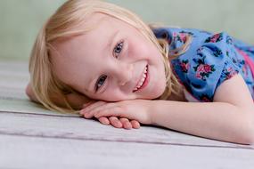 smiling girl with white hair lies on the table