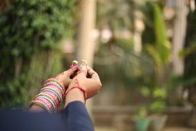 couple holds wedding rings in hands