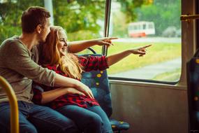 couple in love rides on a bus and watches out the window