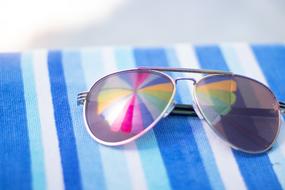 mirroring of colorful beach parasol on sunglasses