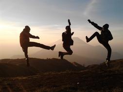 friends jump on top of the mountain
