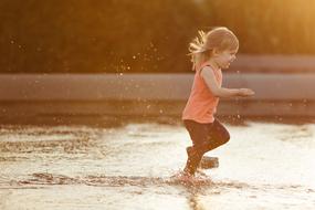 happy Kid runs through water