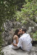 couple in love on a large stone in the forest