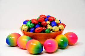 rainbow Colored Easter Eggs and bright chocolates in bowl