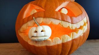 small pumpkin in the mouth of a large pumpkin