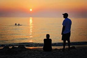 family is resting on the evening beach