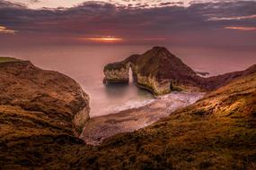 purple Sunrise sky above calm sea and scenic rocky coastline uk, england, bridlington