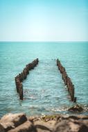 wooden breakwaters near the rocky coast of the sea in Georgia