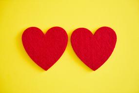 two paper hearts on a yellow background