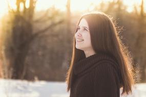 photo of joyful girl with long hair in the winter forest