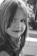 black and white photo of a little girl with makeup