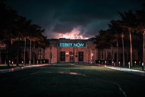 eternity now, lighting words on facade of building at darkness