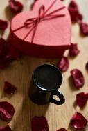 cup of coffee, box of chocolates and rose petals