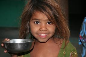 happy Child girl with metal bowl, india, Rajasthan