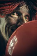 photo of a clown with a red balloon