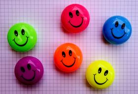 multi-colored emoticons on a sheet in a cage