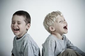 portrait of Happy laughing child Boys sitting back to back