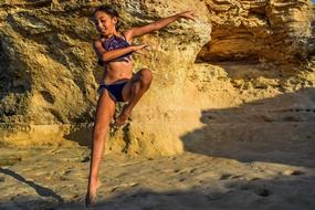 girl in a swimsuit is dancing on the beach