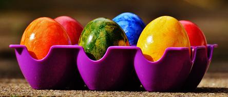 multi-colored easter eggs in a purple stand