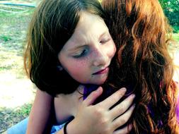two girlfriends hug each other