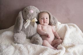 photo of adorable Baby and soft toy rabbit together