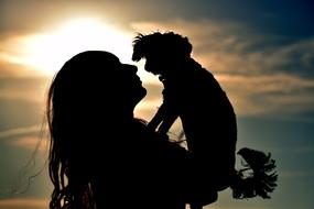 silhouette of a girl with a dog on the background of the evening sky