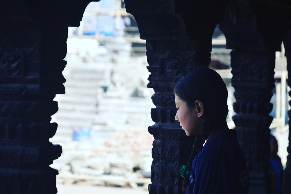 Girl student, looking on the beautiful architecture in light, from the columns