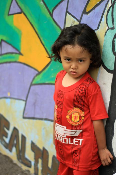 photo of a child on a background wall with graffiti