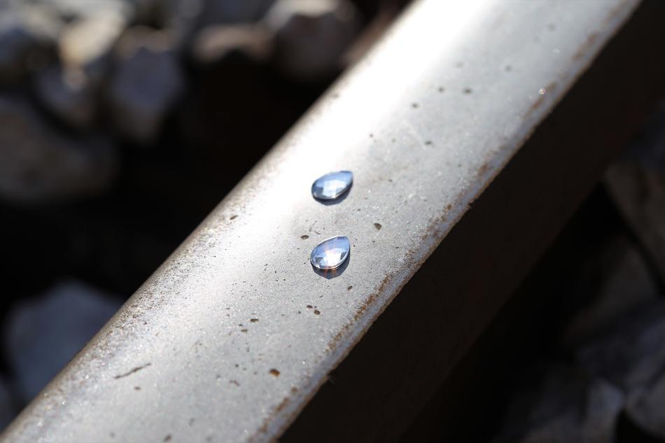 Frozen tears on a railway, with light reflections