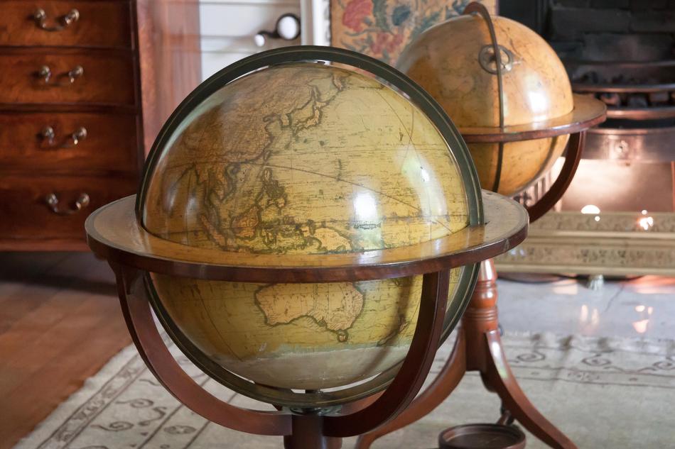 Shiny and colorful globes in the stands, on the map, among the furniture
