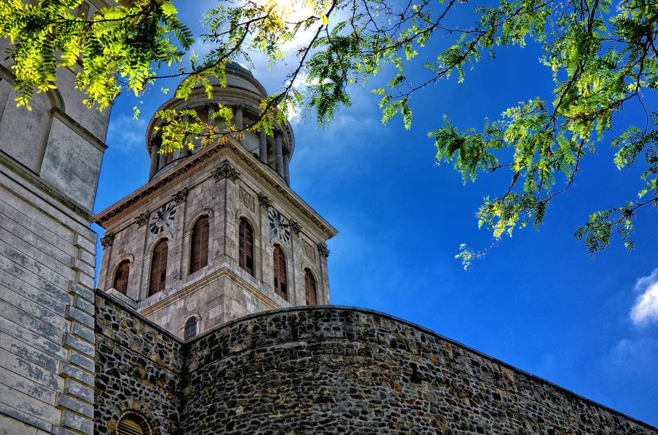 Beautiful tower of Benedictine Pannonhalma Archabbey under a tree at blue summer sky, Hungary