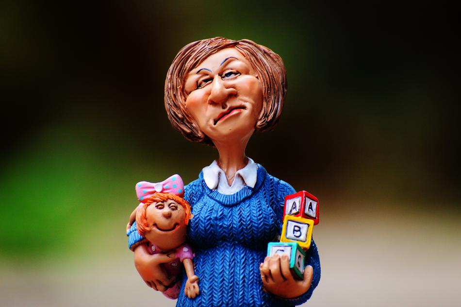 Figure of a baby-sitter with the child and colorful cubes