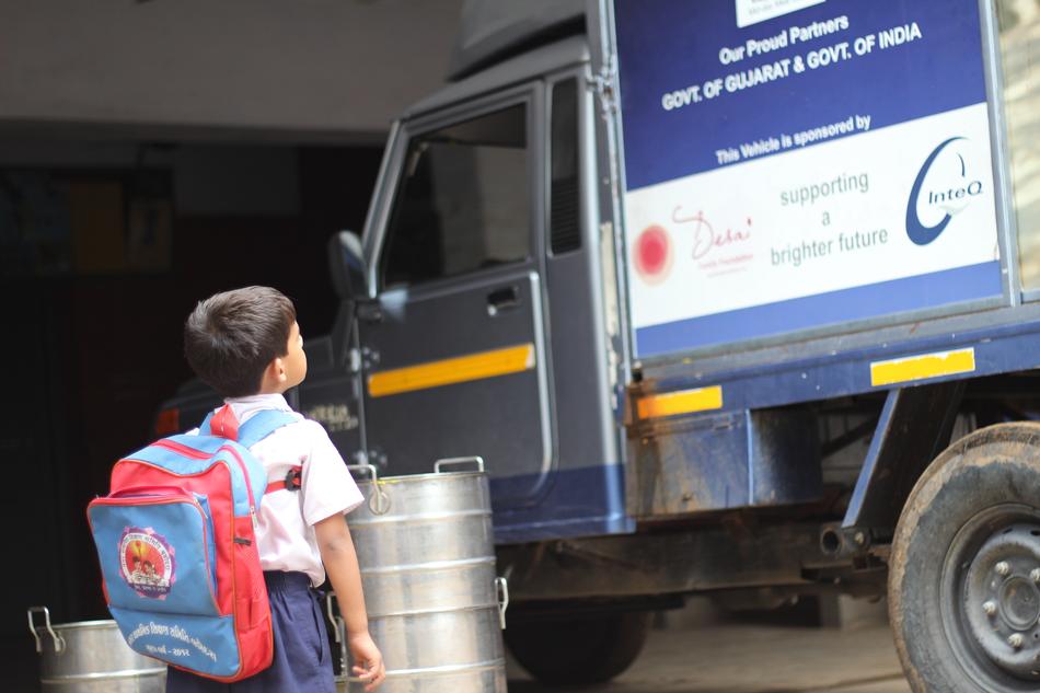 Child boy with the backpack, near the truck, in Gujarat, India