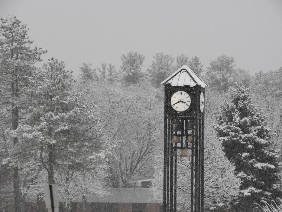 winter photo of a school head with a clock and a bell