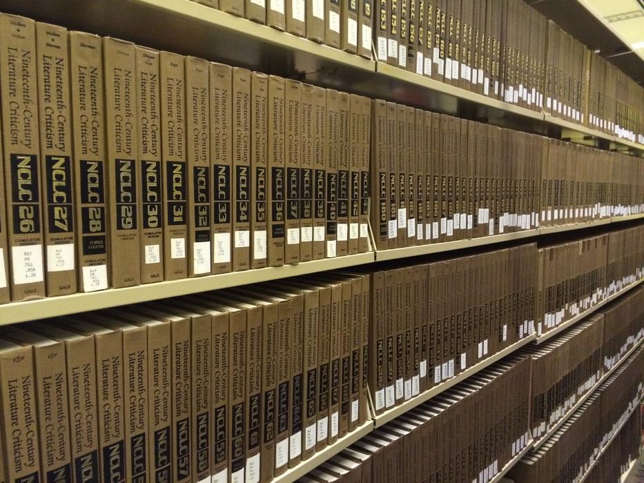 Gold and black books with signs, on the shelves in the library