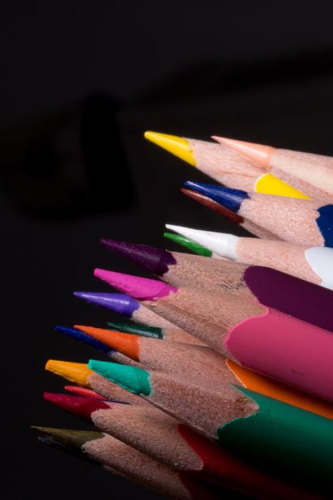 Close-up of the ends of the beautiful, wooden pencils, at black background