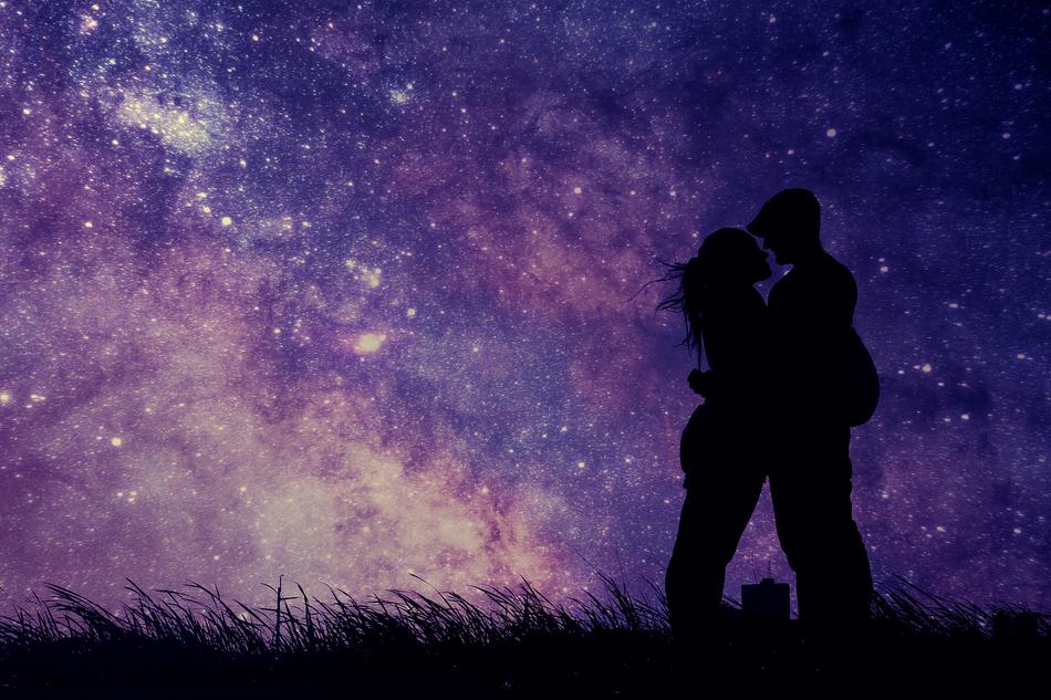 Silhouette of the kissing couple on the magical landscape